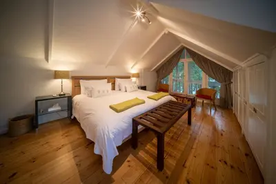 a bedroom with a large white bed and a window at Heron House at Bartholomeus Klip in Hermon
