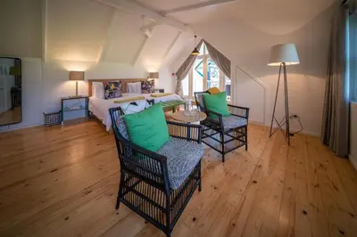 a room with a bed and a table and chairs at Heron House at Bartholomeus Klip in Hermon