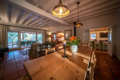 a dining room with a wooden table in a room at Heron House at Bartholomeus Klip in Hermon