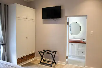 a bedroom with a sink and a television on the wall at LA RÉVERIE in Franschhoek
