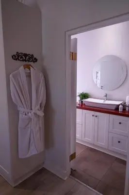 a bathroom with a robe hanging on a door at LA RÉVERIE in Franschhoek