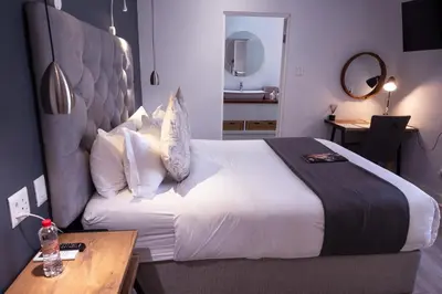 a hotel room with a large bed and a desk at LA RÉVERIE in Franschhoek