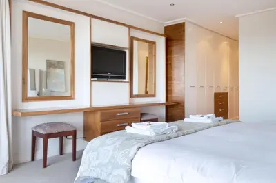 a bedroom with a bed with a tv and a mirror at 74 on Marine in Hermanus