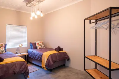 a bedroom with two beds and a bunk bed at Steenbok farm cottages Aalwyn Cottage in Wolseley
