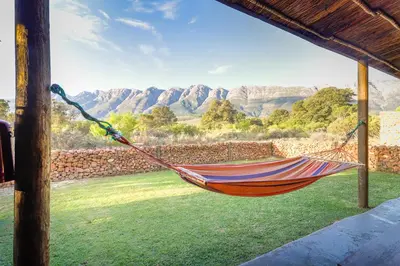 a hammock with a view of the mountains at Steenbok farm cottages Aalwyn Cottage in Wolseley