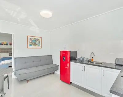 a kitchen with a red refrigerator and a couch at Ocean Way Villas - Self Catering in Cape Town