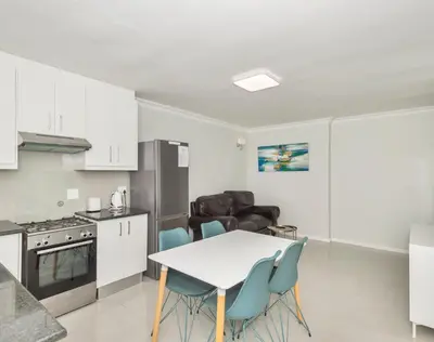 a kitchen and dining room with a table and chairs at Ocean Way Villas - Self Catering in Cape Town