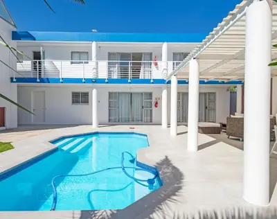 a swimming pool in front of a house at Ocean Way Villas - Self Catering in Cape Town