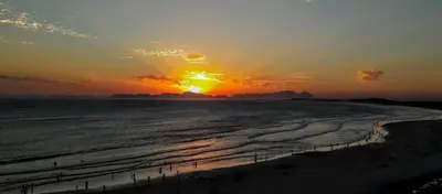 a sunset on the beach with the sun setting at Hibernian Towers 807, Beach Road, Strand in Strand