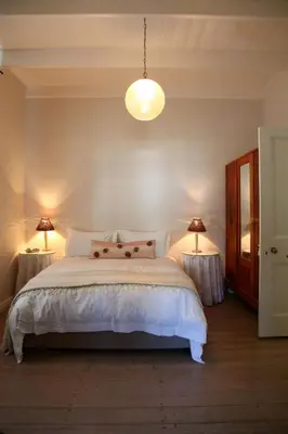 a bedroom with a large bed with two lamps at Verandah House in Hermanus