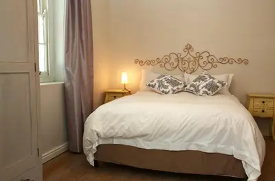 a bedroom with a white bed with pillows on it at Verandah House in Hermanus