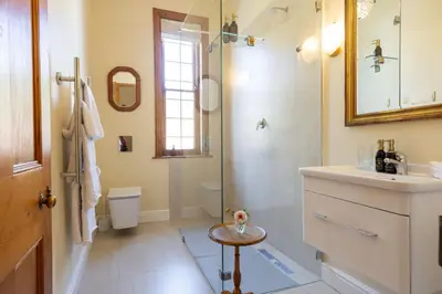 a bathroom with a shower and a sink and a toilet at Villa Puccini in Cape Town