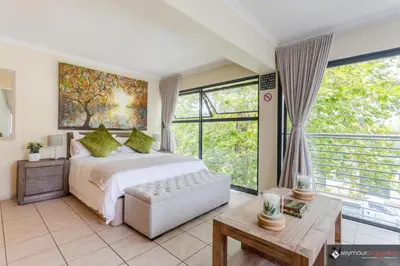 a bedroom with a bed and a large window at CONCORD APARTMENTS Unit 1 in Stellenbosch