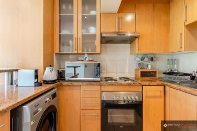 a kitchen with wooden cabinets and a stove top oven at CONCORD APARTMENTS Unit 1 in Stellenbosch