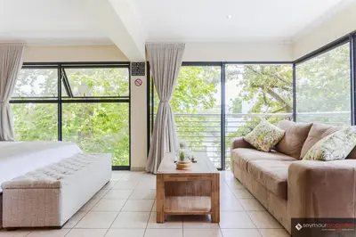 a living room with a bed and a couch at CONCORD APARTMENTS Unit 1 in Stellenbosch