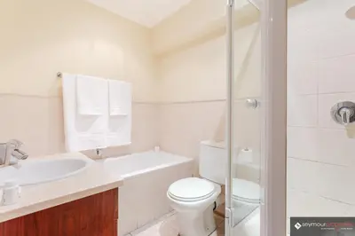 a white bathroom with a toilet and a sink at CONCORD APARTMENTS Unit 1 in Stellenbosch