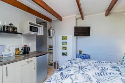a small kitchen with a bed and a counter at Protea Room Franschhoek Central in Franschhoek