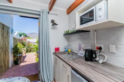 a kitchen with a counter top and a balcony at Protea Room Franschhoek Central in Franschhoek
