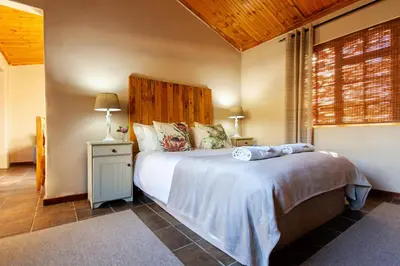a bedroom with a large bed with a wooden headboard at Vergenoegd in Brandwacht