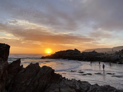 people playing in the ocean at sunset on the beach at Hermanus 60 on Flat in Hermanus