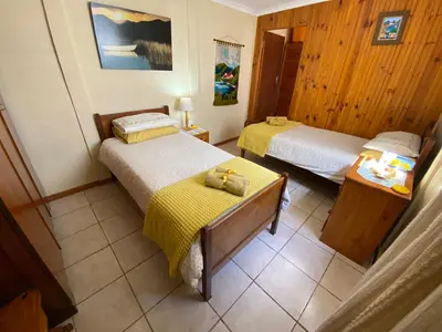 a room with two beds and a table in it at Hermanus 60 on Flat in Hermanus