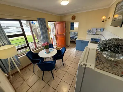 a kitchen with a table and chairs and a table and a kitchen at Hermanus 60 on Flat in Hermanus