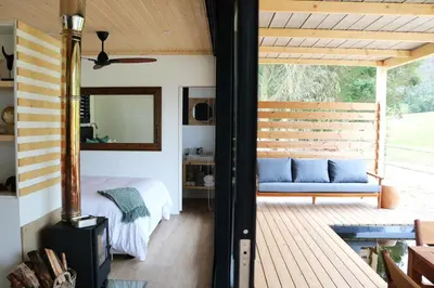 a porch with a blue couch and a mirror at Hemel 'N Aarde Stud in Hermanus