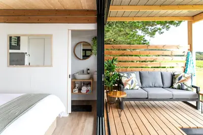 a porch with a couch on a wooden deck at Hemel 'N Aarde Stud in Hermanus