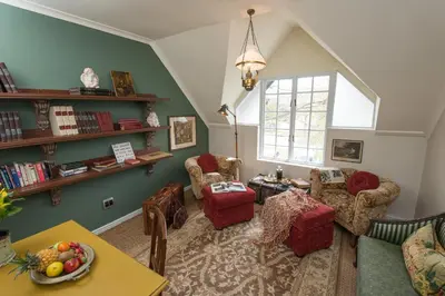 a living room with green walls and a table and chairs at Baruch Guest House Rhodes in Stellenbosch