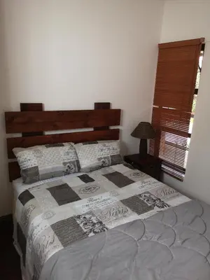 a bedroom with a large bed with a wooden headboard at Bona Lodge in Cape Town