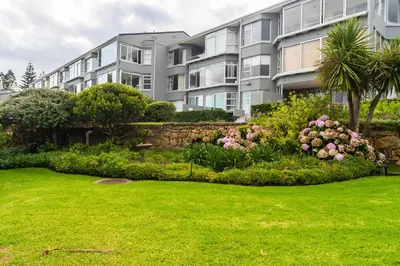 an apartment building with a garden in front of it at Bayview 208 in Hermanus