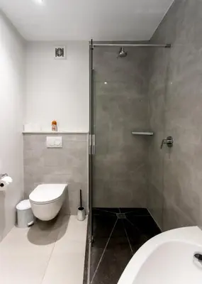 a bathroom with a shower stall and a toilet at Bayview 208 in Hermanus