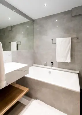 a bathroom with a white tub and a sink at Bayview 208 in Hermanus