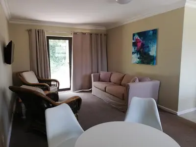 a living room with a couch and chairs at Little Elm Cottage in Cape Town