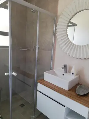 a bathroom with a sink and a mirror at Little Elm Cottage in Cape Town