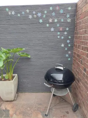 a bbq grill in front of a black wall at The Amaryllis Luxury Apartment Bella Donna in Bettyʼs Bay