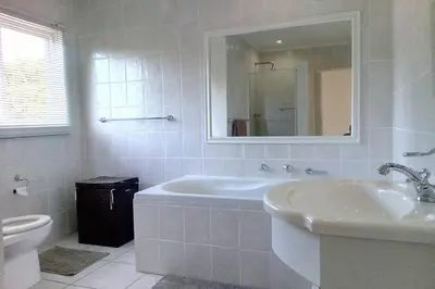 a bathroom with a tub and a sink and a toilet at Somerset-West, Heldervue in Cape Town