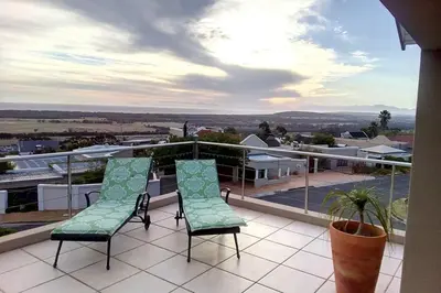 a balcony with two chairs and a view at Somerset-West, Heldervue in Cape Town