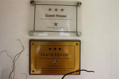 a guest house sign on a wall with four stars at The Vinelands on Alpha Guest House in Cape Town
