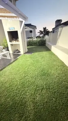 a yard of green grass next to a house at Onrus Holiday Home on Private Estate with Pool in Hermanus