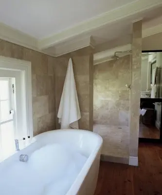 a large white bath tub in a bathroom with a shower at Banksia Boutique Hotel & Spa in Cape Town