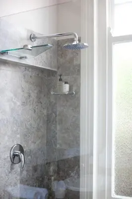 a bathroom with a shower with a glass door at Banksia Boutique Hotel & Spa in Cape Town