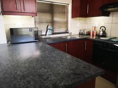 a kitchen with a granite counter top and a sink at Cottage on Norwood in Cape Town