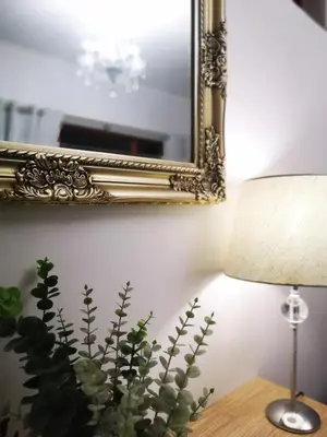 a table with a lamp and a mirror and a plant at Cottage on Norwood in Cape Town