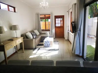 a living room with a couch and a table at Cottage on Norwood in Cape Town