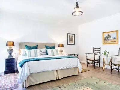 a bedroom with a large bed and a table at Maison Montagne in Franschhoek