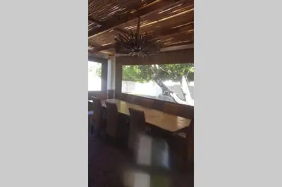 a dining room with a wooden table and chairs at Angel's Place by the Sea in Hermanus