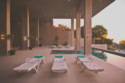 a building with a pool and two chaise lounges at Redrock Ocean View Villa in Cape Town