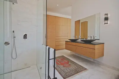 a bathroom with two sinks and a shower at Redrock Ocean View Villa in Cape Town