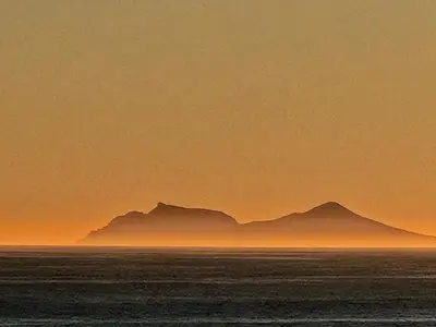 a view of the ocean with mountains in the background at Kleinblom in Pringle in Pringle Bay